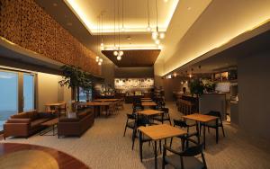 um restaurante com mesas e cadeiras e um bar em Hotel Mazarium em Morioka