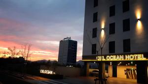 una señal de hotel frente a un edificio al atardecer en Busan Myeongji Ciel Ocean Hotel, en Busan