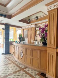 a kitchen with wooden cabinets and a counter with flowers at โรงแรมกู๊ดเรสซิเดนซ์ - Good Residence in Nong Khae