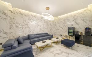 a living room with a blue couch and a marble wall at Busan Myeongji Ciel Ocean Hotel in Busan