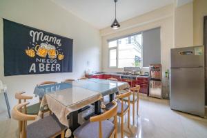 a kitchen with a table and chairs and a refrigerator at Cheers乾杯包棟民宿 in Yuanshan