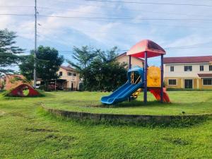 a playground with a slide in the grass at 2 storey Camella Homes in Pagadian City in Pagadian