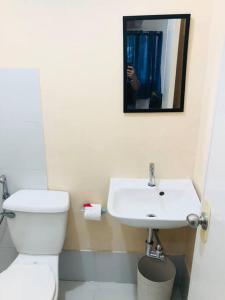 La salle de bains est pourvue de toilettes blanches et d'un lavabo. dans l'établissement 2 storey Camella Homes in Pagadian City, à Pagadian