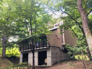 een oud huis met een balkon in het bos bij Labo Land Kurohime in Shinano