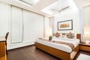 1 dormitorio con cama y ventana grande en FabHotel Prime Avenue, en Indore