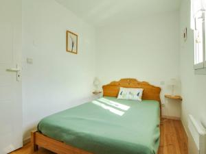 ein Schlafzimmer mit einem Bett mit einem hölzernen Kopfteil in der Unterkunft Triplex Calme 6 Pers, Terrasse, Parking, Proche Station Ski - FR-1-402-90 in Esquièze - Sère