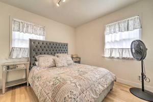 a bedroom with a bed with a fan and two windows at Sunny Sierra Valley Cottage Hike and Explore! 