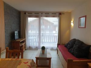 a living room with a couch and a large window at Appartement Les Orres, 2 pièces, 4 personnes - FR-1-322-432 in Les Orres