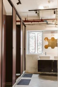 La salle de bains est pourvue d'un lavabo et d'une fenêtre. dans l'établissement 7 Wonders Hostel @ Boat Quay, à Singapour