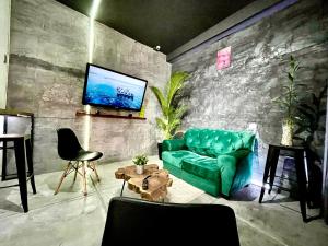 - un salon avec un canapé vert et une télévision dans l'établissement Zyan Rooms, à Villahermosa