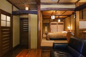 - une chambre avec un lit et un canapé dans l'établissement Kurokawa Onsen Oyado Noshiyu, à Minamioguni