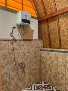 um chuveiro na casa de banho com um chuveiro montado na parede em Besakih Homestay & Villa em Besakih