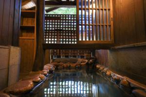 Habitación con piscina de agua en un edificio en Kurokawa Onsen Oyado Noshiyu en Minamioguni
