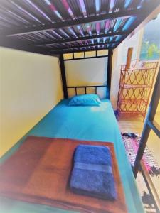 a bedroom with a bed with a blue bedspread at The Cocoon in Phumĭ Chroŭy Svay