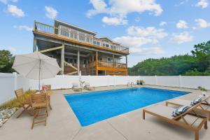 una piscina con sillas y una casa en Ss OBX SS111, en Southern Shores