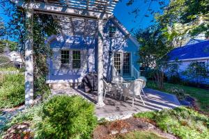 a patio in front of a blue house at Wisteria Cottage in Camden