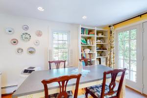 a dining room with a table and chairs at Wisteria Cottage in Camden