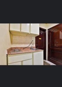 a kitchen with white cabinets and a sink at ريتاج الفضية للوحدات السكنية in Al Madinah