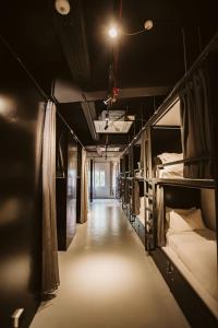 un long couloir avec des lits superposés dans une chambre dans l'établissement 7 Wonders Hostel @ Boat Quay, à Singapour