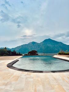 a swimming pool with mountains in the background at The Breezy Volcano in Kintamani