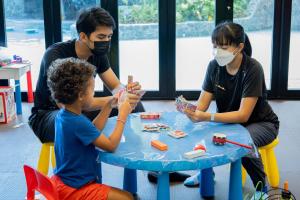 twee volwassenen en een kind die met lego spelen bij Sea Seeker Krabi Resort - SHA Extra Plus in Ao Nang Beach