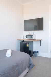 Schlafzimmer mit einem Bett und einem Flachbild-TV in der Unterkunft Seven Seas Hotel in Carrington