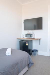 ein Schlafzimmer mit einem Bett und einem Flachbildfernseher in der Unterkunft Seven Seas Hotel in Carrington + 2 Fotos
