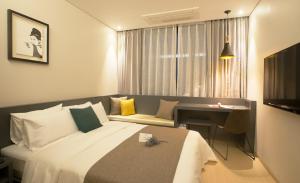 清州市Gloucester Hotel Cheongju的配有床和书桌的酒店房间 更多23张照片
