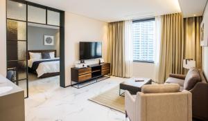 清州市Gloucester Hotel Cheongju的一间带床和客厅的酒店房间