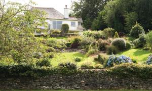 a garden in front of a white house at Harrison Stickle in Bowness-on-Windermere
