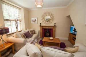 a living room with a couch and a fireplace at Acorn Cottage in Ambleside