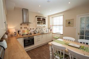a kitchen with a table and a stove top oven at Acorn Cottage in Ambleside