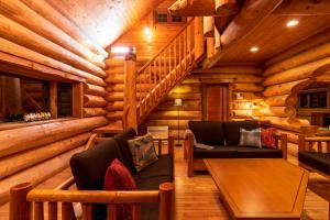 Cabaña de madera con sala de estar con sofás y escalera en Suite Villa Hakone Sengokuhara Canadian Log, en Hakone