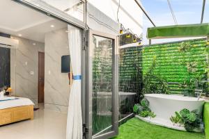 ein Badezimmer mit einer Badewanne und einer grünen Wand in der Unterkunft KISS Hotel Tân Bình in Ho-Chi-Minh-Stadt