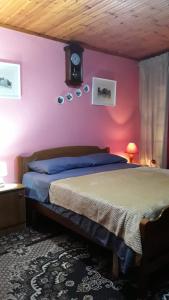 a bedroom with a bed and a pink wall at Rooms for Rent in Shkodër