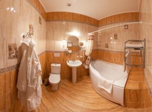 a bathroom with a tub and a toilet and a sink at Anturage Hotel in Saint Petersburg