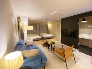 a living room with a blue couch and a bedroom at precious days inn in Fukuoka