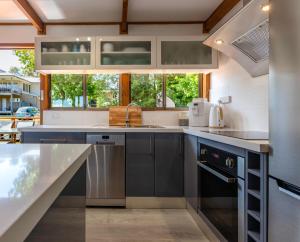 a kitchen with stainless steel appliances and a large window at Surf Beach Escape in Surf Beach
