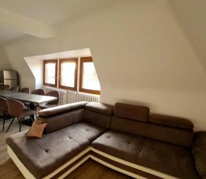 sala de estar con sofá de cuero y mesa en Auberge SYRA/ Proche Europa Park en Marckolsheim