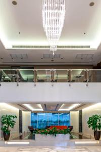 eine große Lobby mit einem Kronleuchter in einem Gebäude in der Unterkunft Jasmine Grande Residence in Bangkok