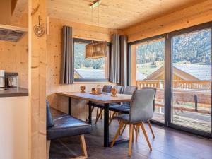 een eetkamer met een tafel en stoelen en een groot raam bij Gorgeous Chalet in Steinach am Brenner near Ski Area in Steinach am Brenner