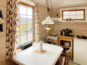 a kitchen with a white table in a small kitchen at Three-Bedroom Holiday home in Åkra in Kyrping