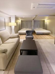 ein Wohnzimmer mit einem Sofa und 2 Betten in der Unterkunft precious days inn in Fukuoka