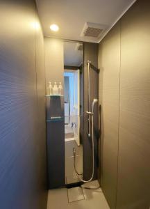 een badkamer met een douche en een toilet. bij precious days inn in Fukuoka