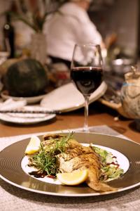 um prato de comida numa mesa com um copo de vinho em precious days inn em Fukuoka