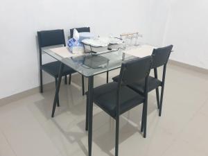 szklany stół i krzesła z płytami i okularami w obiekcie HAPDESKO HOMESTAY w mieście Batam Center