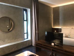 a bedroom with a bed and a mirror and a television at NAI YA Hotel -SHA Extra Plus in Chiang Rai