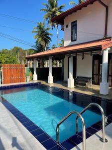 a swimming pool in front of a house at River Breeze Villa Bentota in Bentota