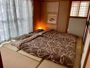 1 cama grande en un dormitorio con ventana en season guest house, en Tokio