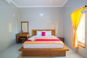A bed or beds in a room at RedDoorz at Tanjung Alam Hotel Lovina